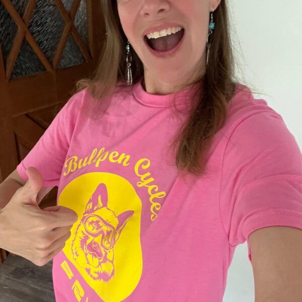 Smiling person in pink dog T-shirt thumbs-up
