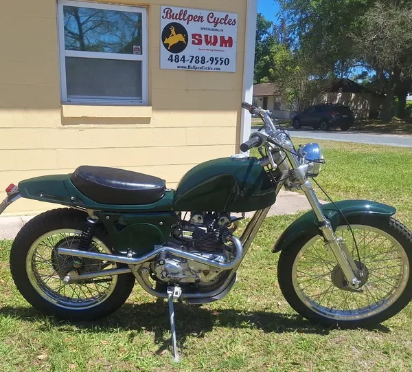 Retro motorcycle beside yellow building