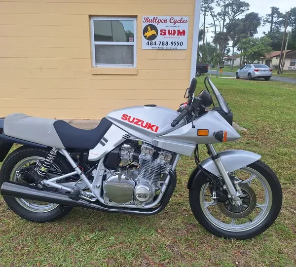 Silver Suzuki motorcycle parked on grass