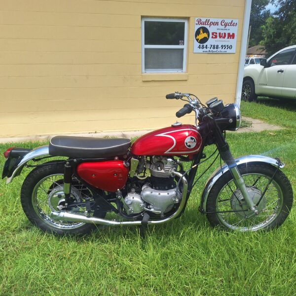 Red vintage motorcycle parked on grass