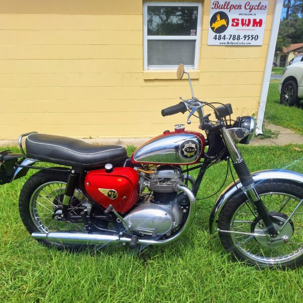 Vintage red chrome motorcycle parked on grass